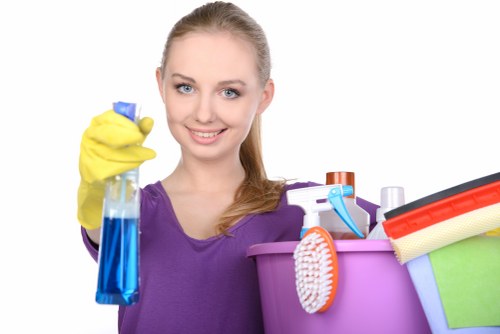 Technician using upholstery cleaning equipment on a fabric sofa